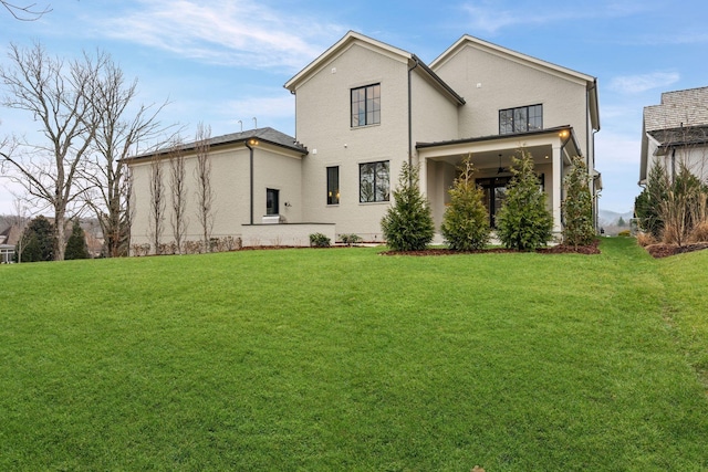 back of house with a yard and stucco siding