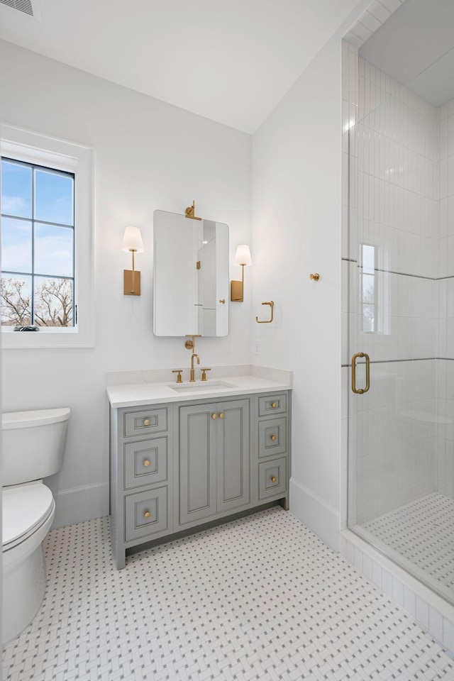 bathroom featuring baseboards, a shower stall, toilet, and vanity