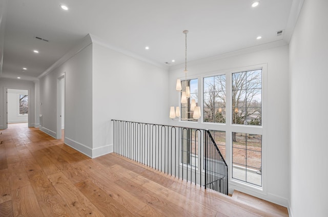 corridor with crown molding, recessed lighting, baseboards, and light wood-style floors