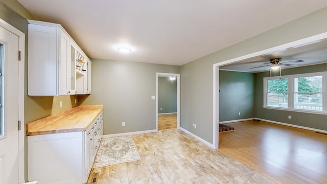 kitchen with white cabinets, light wood-type flooring, and wooden counters