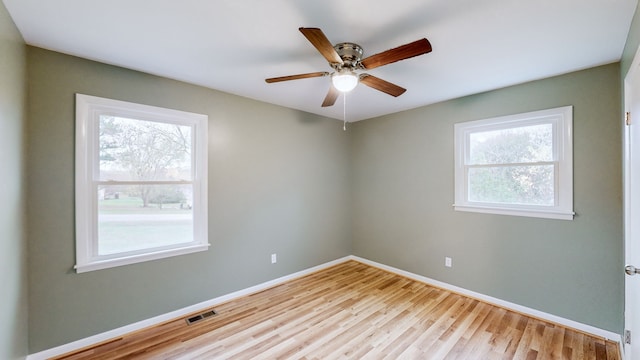 unfurnished room with ceiling fan, a healthy amount of sunlight, and light wood-type flooring