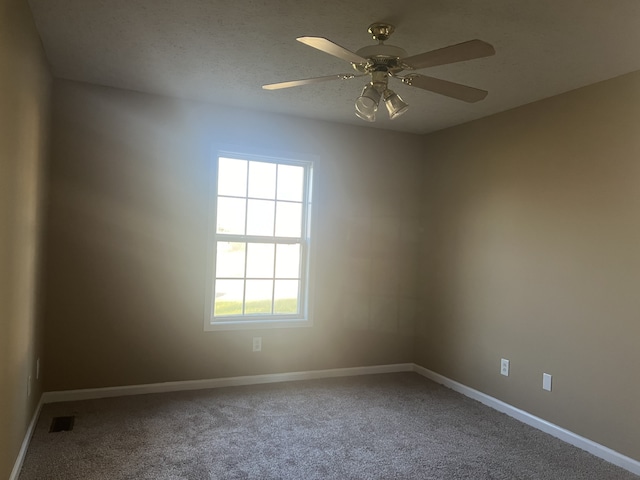 carpeted spare room featuring a textured ceiling and ceiling fan