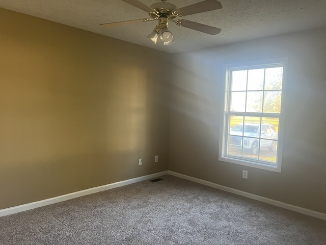 carpeted spare room featuring ceiling fan and a textured ceiling