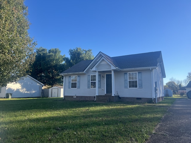 view of front of home featuring a front yard and a storage unit