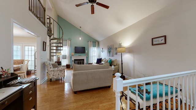 living room featuring ceiling fan, light wood-type flooring, and high vaulted ceiling