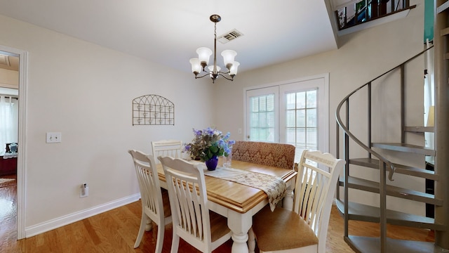 dining space featuring light hardwood / wood-style floors and a chandelier