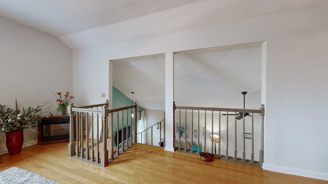 stairs featuring wood-type flooring and lofted ceiling