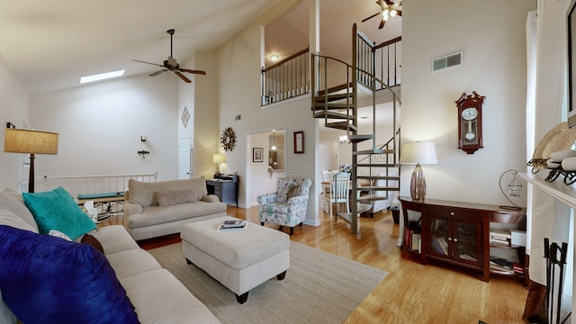 living room with ceiling fan, high vaulted ceiling, and light wood-type flooring