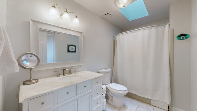 bathroom with vanity, tile patterned floors, a shower with curtain, a skylight, and toilet