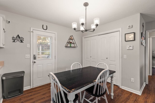 dining area with dark hardwood / wood-style flooring and a notable chandelier