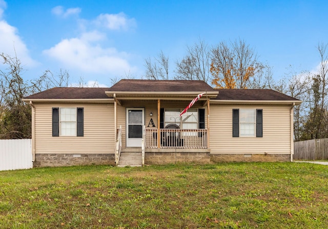 ranch-style home featuring covered porch and a front lawn