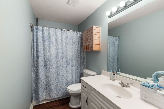 bathroom with toilet, vanity, a textured ceiling, and hardwood / wood-style flooring