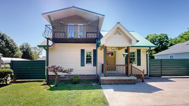 view of front of property with a front yard and a balcony