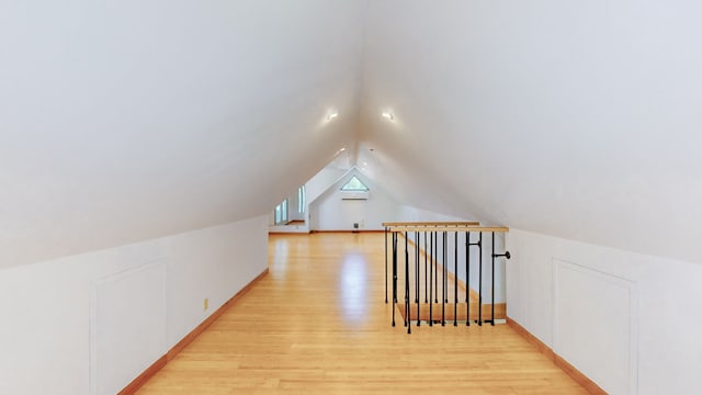 additional living space with lofted ceiling and light wood-type flooring