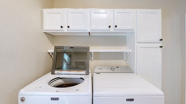 laundry room with washer and clothes dryer and cabinets