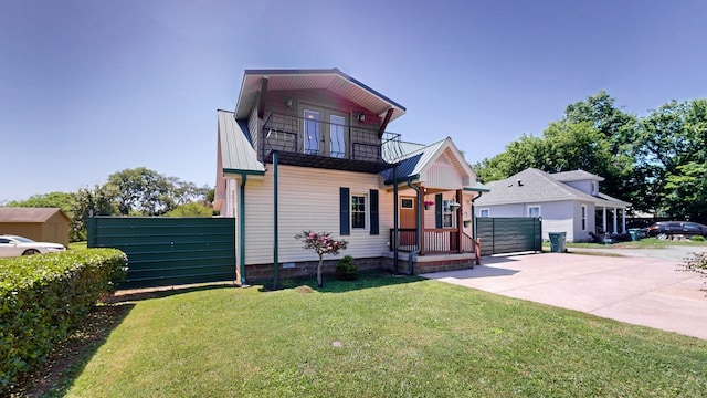 view of front of home featuring a balcony and a front lawn