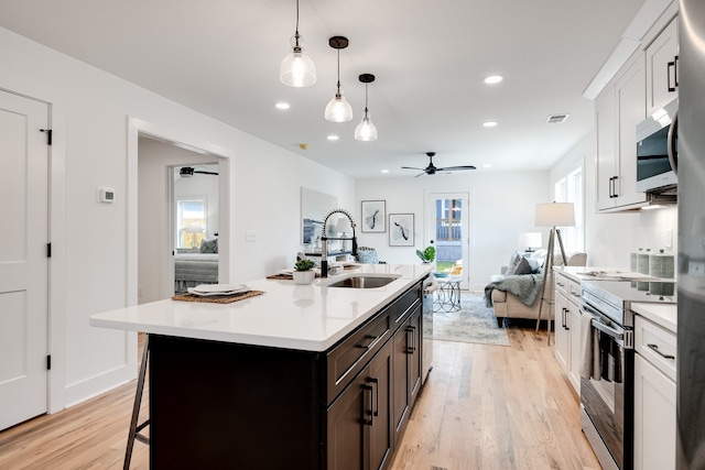 kitchen with sink, white cabinets, plenty of natural light, and appliances with stainless steel finishes