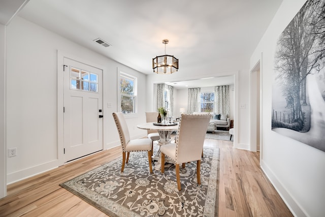 dining area featuring light hardwood / wood-style floors and a chandelier