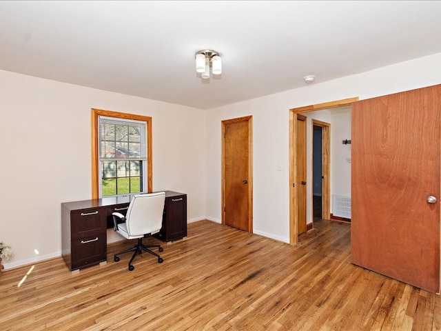 home office with light hardwood / wood-style flooring