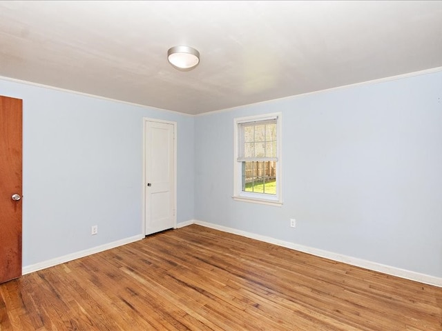 unfurnished room featuring crown molding and light wood-type flooring