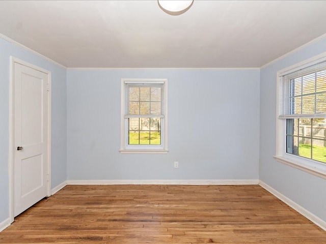 empty room with ornamental molding and light wood-type flooring