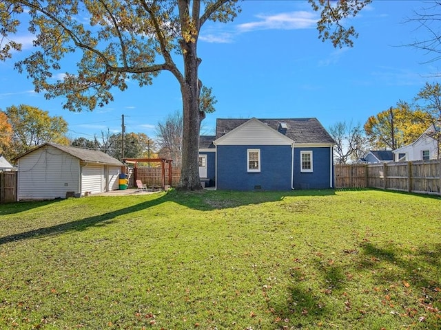 rear view of property with a yard and an outdoor structure