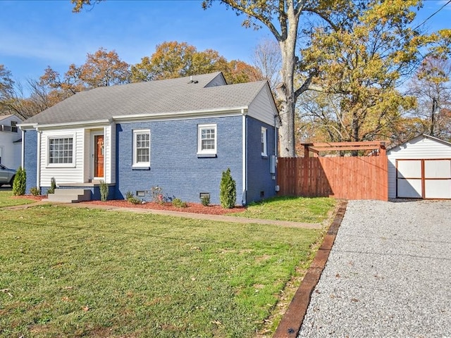 view of front of house with a front lawn and a storage shed