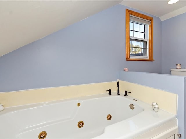 bathroom with a bath and vaulted ceiling