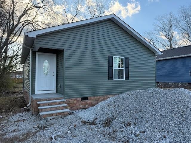 view of front of house with crawl space and gravel driveway