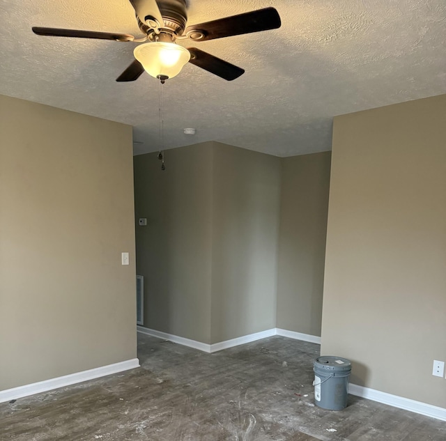 empty room with unfinished concrete flooring, a textured ceiling, baseboards, and ceiling fan