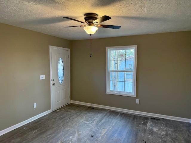entrance foyer featuring a textured ceiling, wood finished floors, baseboards, and ceiling fan