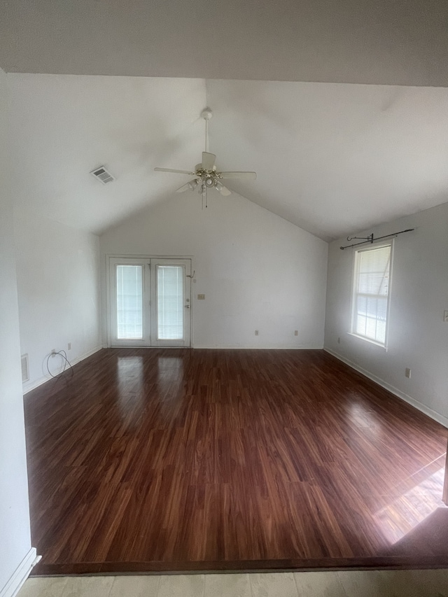 empty room featuring hardwood / wood-style floors, french doors, vaulted ceiling, and ceiling fan