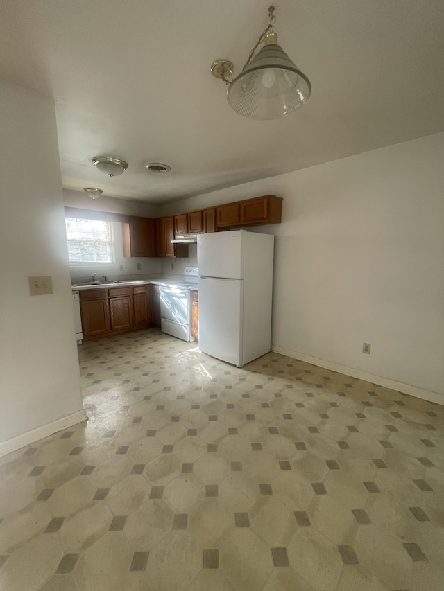 kitchen featuring white appliances and hanging light fixtures