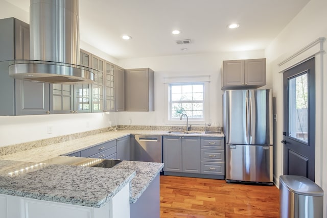 kitchen with sink, stainless steel appliances, light hardwood / wood-style flooring, plenty of natural light, and extractor fan