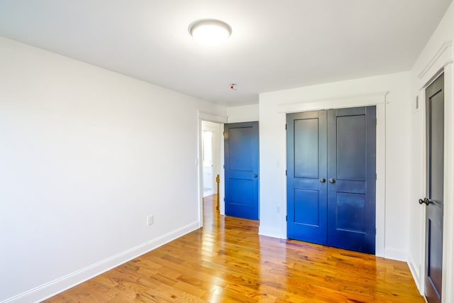 unfurnished bedroom featuring hardwood / wood-style flooring and a closet