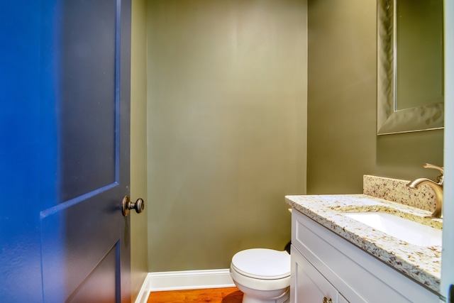 bathroom with vanity, toilet, and wood-type flooring