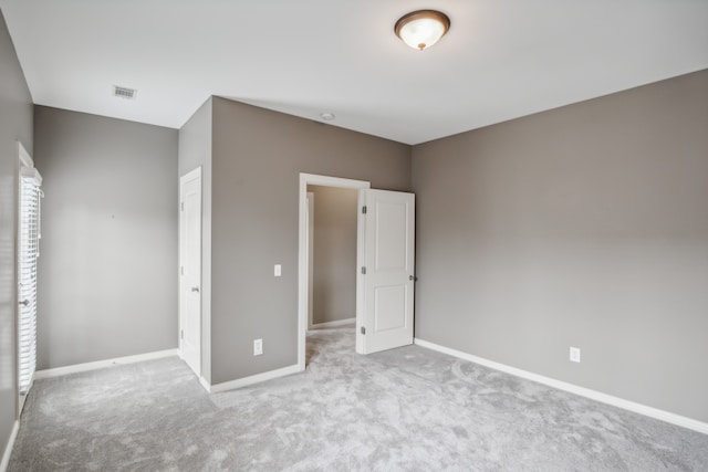 unfurnished bedroom with light carpet and a closet