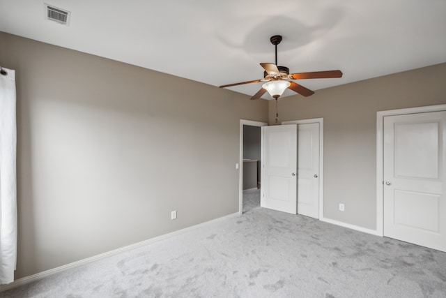 unfurnished bedroom with light colored carpet and ceiling fan