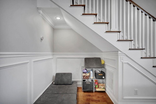 staircase featuring ornamental molding and hardwood / wood-style flooring