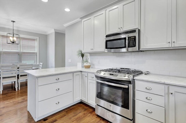 kitchen with crown molding, light wood-type flooring, white cabinetry, kitchen peninsula, and stainless steel appliances