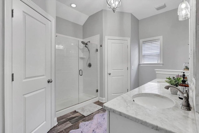 bathroom with vanity, hardwood / wood-style floors, lofted ceiling, and a shower with shower door