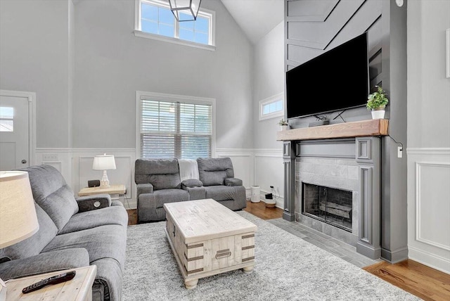 living room with hardwood / wood-style floors, high vaulted ceiling, and plenty of natural light