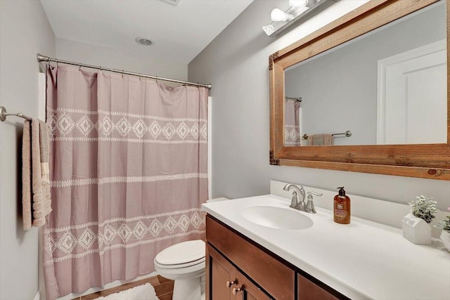 bathroom with toilet, vanity, and tile patterned floors