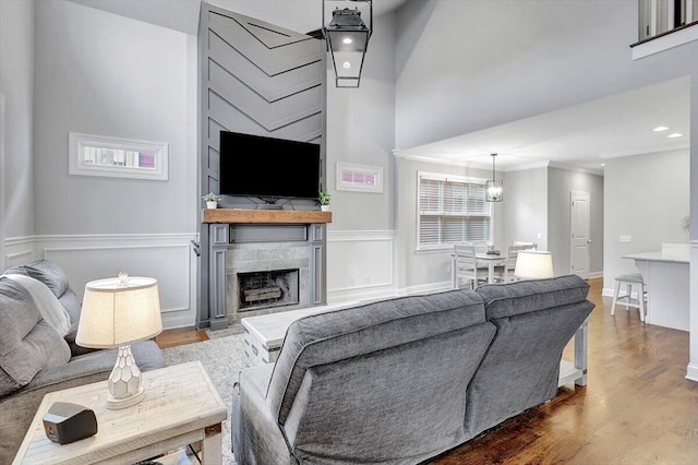 living room featuring hardwood / wood-style floors, a notable chandelier, and a towering ceiling