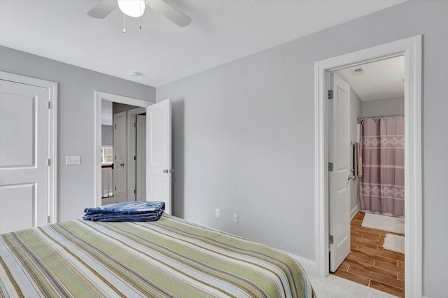 bedroom featuring ceiling fan, light wood-type flooring, and connected bathroom