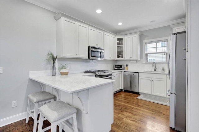 kitchen featuring white cabinetry, stainless steel appliances, and a breakfast bar area