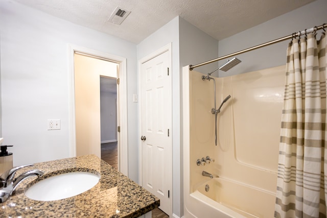 bathroom with shower / bath combination with curtain, a textured ceiling, hardwood / wood-style flooring, and sink