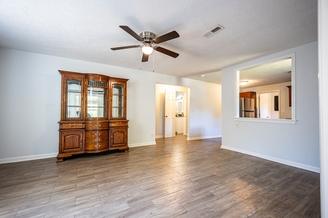 unfurnished room with ceiling fan, light wood-type flooring, and a textured ceiling