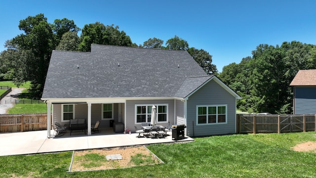 rear view of house featuring a yard, a patio, fence, and roof with shingles