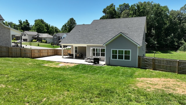 rear view of house with a patio area, a fenced backyard, and a yard